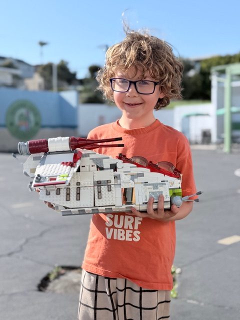 Student with his Lego build at after-school enrichment